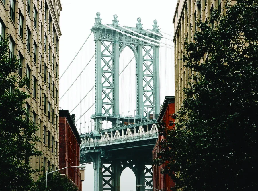 Manhattan Bridge framed between brick buildings in DUMBO, Brooklyn