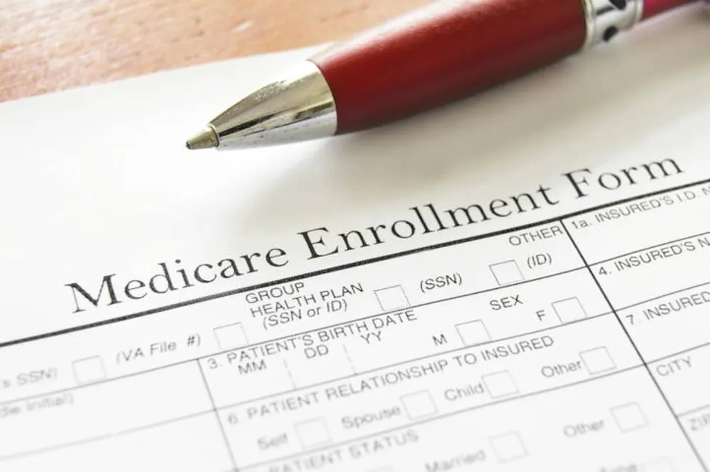 Medicare enrollment form with a pen resting on it